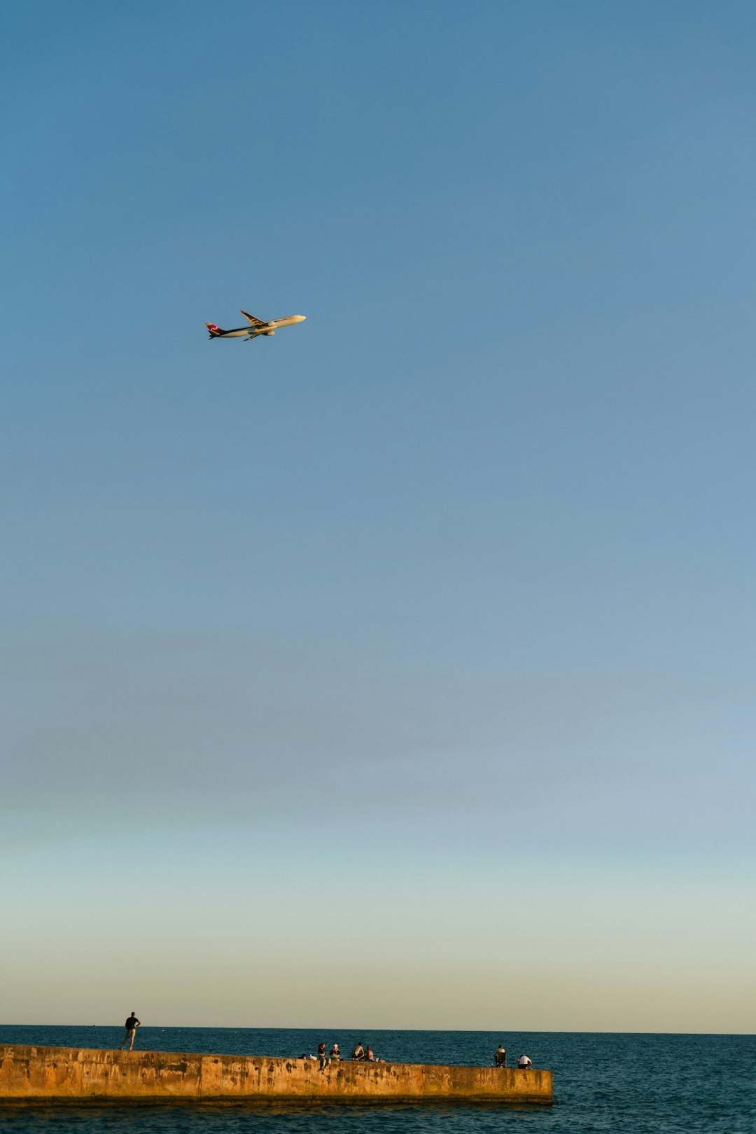 a-plane-flying-over-a-body-of-water-0xlc-pk-br8