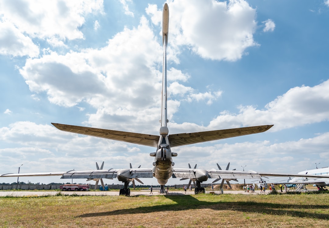 gray-fighter-plane-on-green-grass-field-under-blue-and-white-sunny-cloudy-sky-during-daytime-2hsugmjn2ao